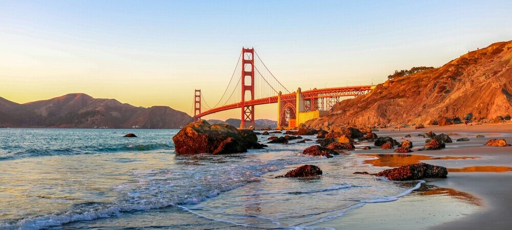 The Golden Gate Bridge seen from a beach at sunset