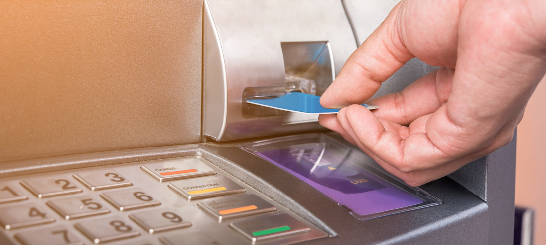 Close-up of person using an ATM